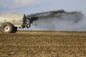 tracteur qui répend des fertilisants organiques dans un champ